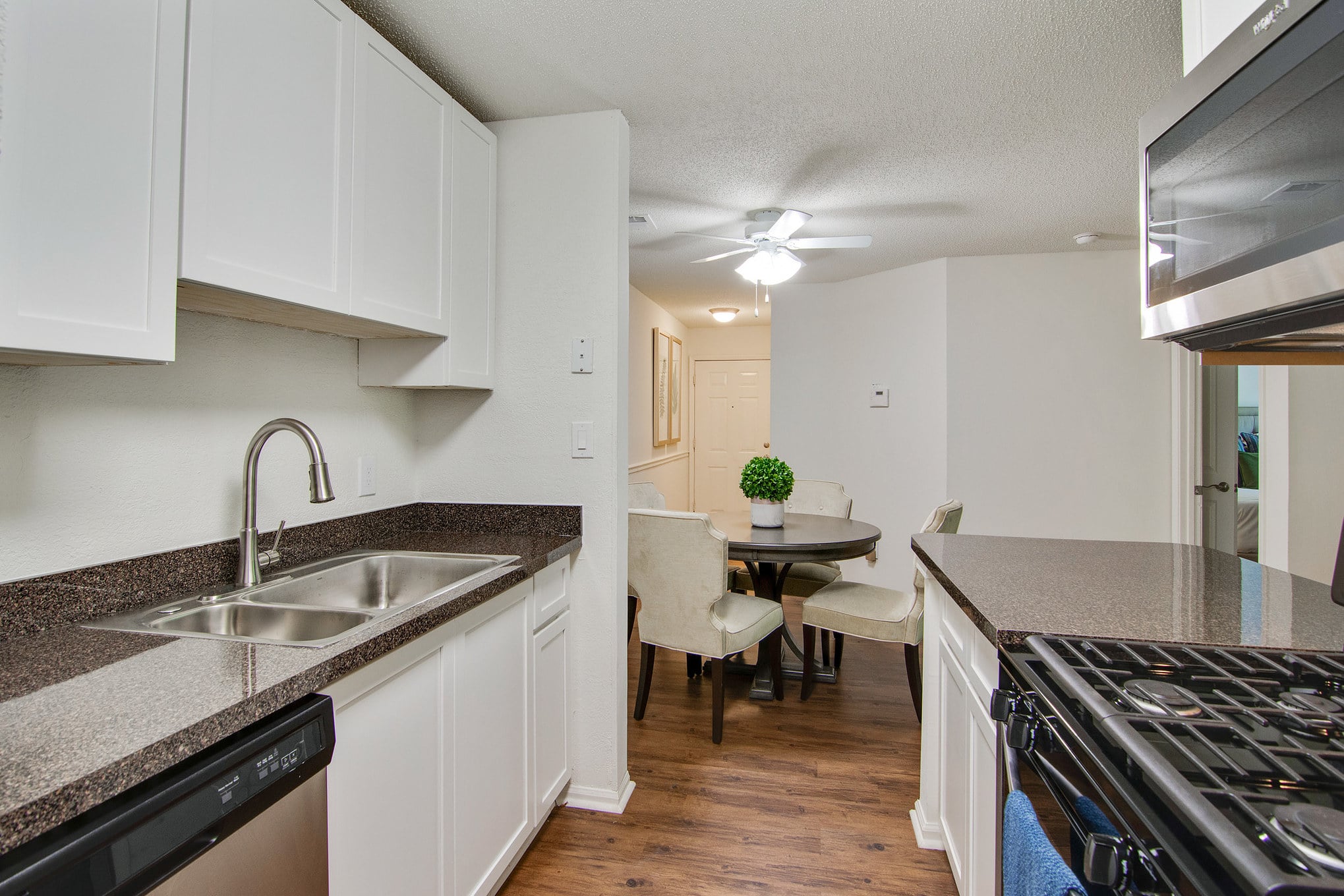 A two bedroom apartment with a kitchen featuring stainless steel appliances and white cabinets.