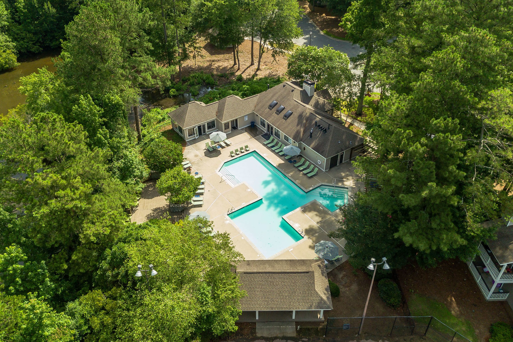 An aerial view of a pool surrounded by trees, ideal for residents of a two bedroom apartment looking for a relaxing outdoor space.
