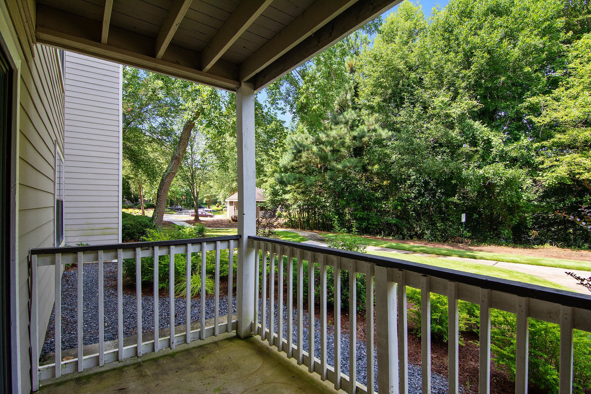 Grove Parkview Apartments in Stone Mountain A Two Bedroom Apartment with a balcony offering a view of a wooded area.
